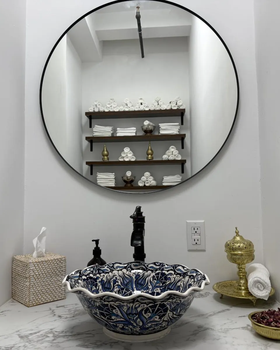 A blue-and-white basin, brass details and rolled towels in the studio