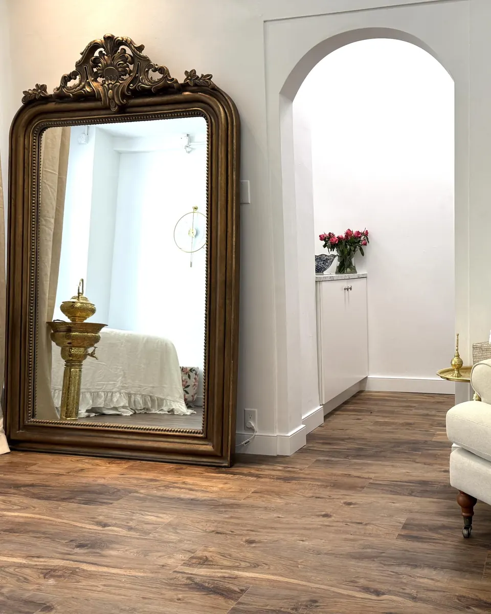 A gilt mirror and an arched doorway in the studio