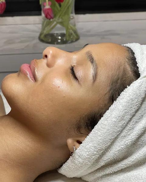 A client resting with eyes closed, hair wrapped in a towel