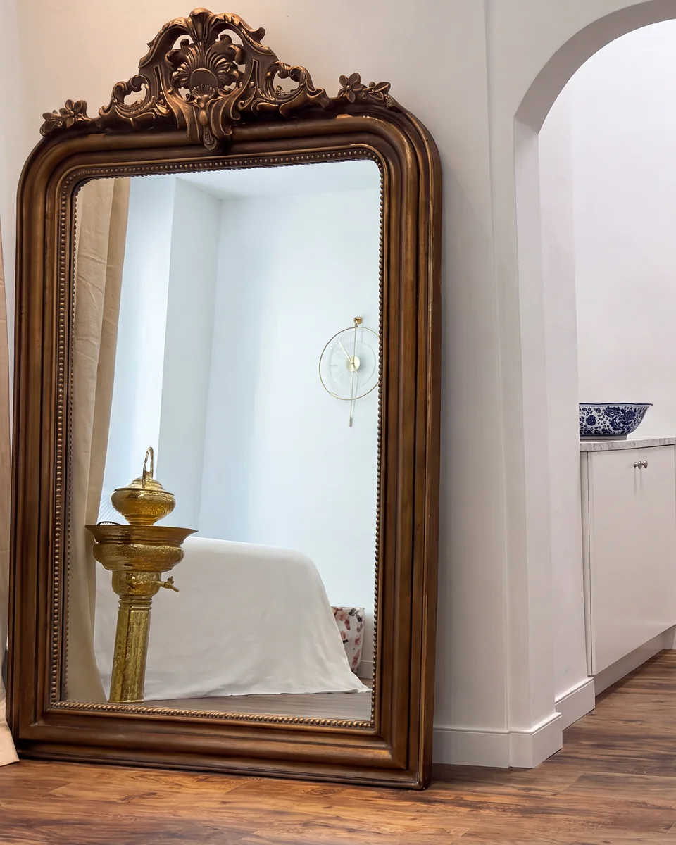 A gilt mirror and an arched doorway in the studio